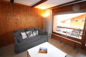 - un salon avec un canapé et une grande fenêtre dans l'établissement Mondzeu C261, à Bagnes