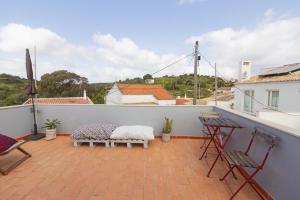 a balcony with two chairs and a table at Casa Oceano-Mar a vista in Raposeira