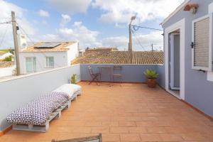 ein Balkon mit zwei Bänken auf einem Dach in der Unterkunft Casa Oceano-Mar a vista in Raposeira + 39 Fotos