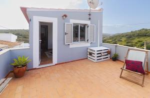 ein Balkon eines Hauses mit einem Stuhl und einem Fenster in der Unterkunft Casa Oceano-Mar a vista in Raposeira