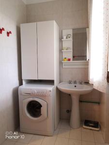 ein Badezimmer mit einer Waschmaschine und einem Waschbecken in der Unterkunft Casa sul mare Adriatico in Cavallino-Treporti