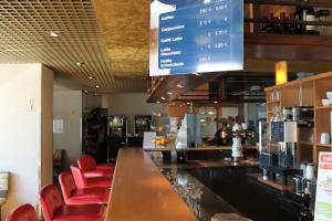 a restaurant with a bar with red leather chairs at Hotel Grunewald in Berlin