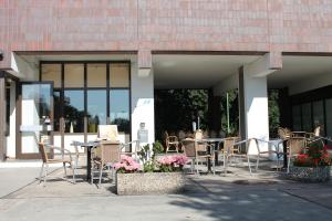 Eine Gruppe von Tischen und Stühlen vor einem Gebäude in der Unterkunft Hotel Grunewald in Berlin