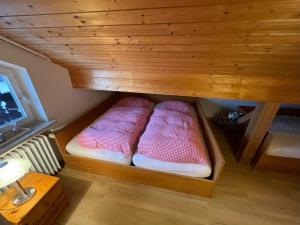 two beds in a small room with a wooden ceiling at Alpenblick in Farchant