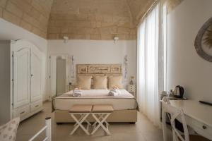 a bedroom with a bed and a desk in a room at Amatè Suite in Lecce