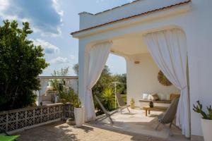 d'une terrasse avec des rideaux blancs et un canapé. dans l'établissement Dimora il Fico D'India, à Ostuni