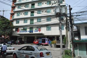 a building with cars parked in front of it at Dragon Home Inn in Cebu City