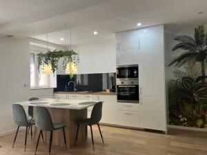 a kitchen with white cabinets and a table and chairs at Appartement Luxe Jaune in Saint Etienne