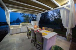 an outdoor kitchen with a table and chairs at Dimora il Fico D'India in Ostuni