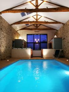 uma grande piscina num quarto com uma grande janela em L'Escale du Bocage Piscine couverte chauffée em La Flocellière