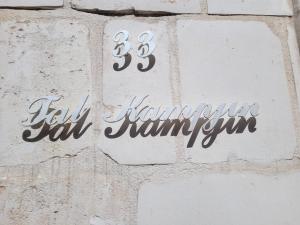 a sign on the side of a brick wall at Tal-Kampjin in Mellieħa