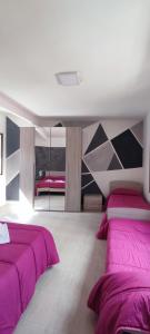a bedroom with two beds with purple sheets at I Cappuccini Rooms in Catania