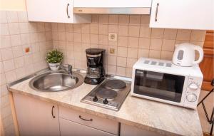 a kitchen counter with a microwave and a sink at Lovely Apartment In Podstrana in Podstrana