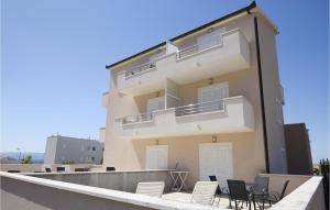 a large apartment building with chairs on the balcony at Lovely Apartment In Podstrana in Podstrana