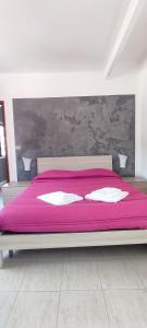 1 dormitorio con cama rosa y manta rosa en I Cappuccini Rooms, en Catania