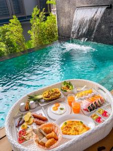 ラヤンビーチにあるAKRA Collection Layan - Hideaway Villasのプールの横のテーブルに置かれた食べ物のトレイ