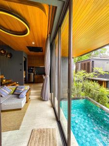 ein Haus mit einem Pool und einem Wohnzimmer in der Unterkunft AKRA Collection Layan in Layan Beach