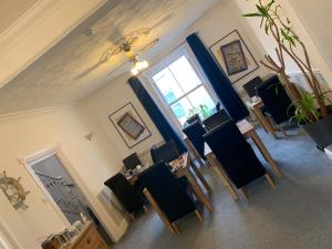 uma sala de jantar com cadeiras pretas e uma janela em Gumfreston Guest House em Tenby