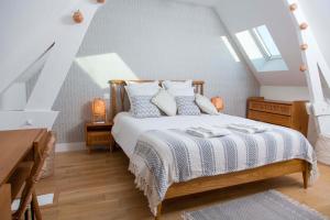 een slaapkamer met een bed met een witte deken bij Gîtes de La Vesée in La Chapelle dʼArmentières