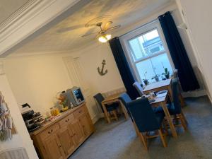 ein Esszimmer mit einem Tisch und einem Fenster in der Unterkunft Gumfreston Guest House in Tenby
