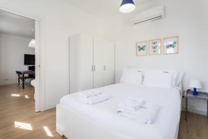 a white bedroom with a large white bed with white pillows at FLH Marquês Charming Flats in Lisbon
