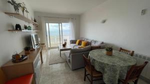uma sala de estar com uma mesa e um sofá em Bonito apartamento en Roses con vistas al mar em Roses