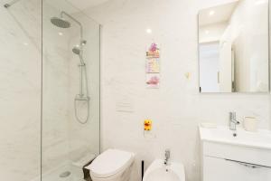 a white bathroom with a toilet and a sink at FLH Marquês Charming Flats in Lisbon