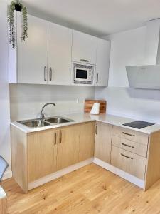 a kitchen with white cabinets and a sink at APARTAMENTO CAMINO DEL RIO in Ardales