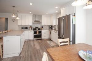 a kitchen with white cabinets and a table and a refrigerator at Lazy Day-Z in Virginia Beach