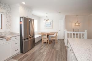 a kitchen with a table and a stainless steel refrigerator at Lazy Day-Z in Virginia Beach