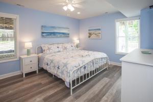 a blue bedroom with a bed and two windows at Lazy Day-Z in Virginia Beach