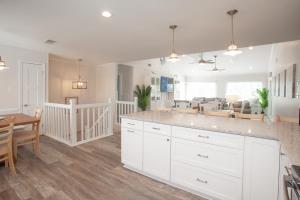 a kitchen and dining room with white cabinets and a table at Lazy Day-Z in Virginia Beach