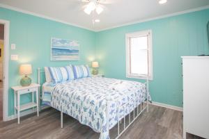 a blue bedroom with a bed and a window at Lazy Day-Z in Virginia Beach