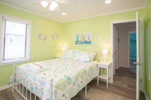 a bedroom with green walls and a bed and a window at Lazy Day-Z in Virginia Beach