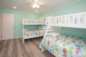 a bedroom with two bunk beds and a ceiling fan at Lazy Day-Z in Virginia Beach