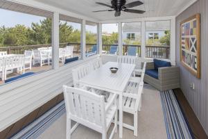 a porch with a white table and chairs at Lazy Day-Z in Virginia Beach