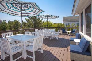 a deck with white chairs and tables and umbrellas at Lazy Day-Z in Virginia Beach