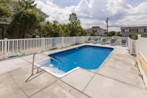 a swimming pool with chairs and a fence at Lazy Day-Z in Virginia Beach