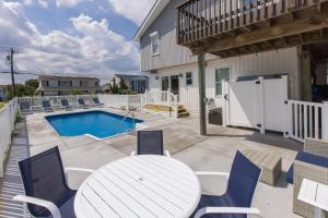 a patio with a table and chairs and a pool at Lazy Day-Z in Virginia Beach