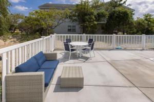 a patio with a table and chairs and a white fence at Lazy Day-Z in Virginia Beach