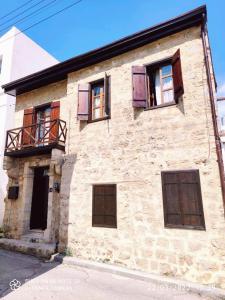 an old stone building with wooden doors and windows at Malia Fountain House in Famagusta