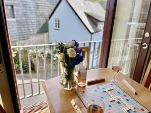 a vase of flowers sitting on a table on a balcony at Shippon End - Barn conversion with character and charm in Dittisham