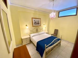 1 dormitorio con 1 cama y 1 silla en Apartments Mikros, en Giardini Naxos