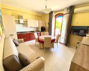 sala de estar y cocina con sofá y mesa en Apartments Mikros en Giardini Naxos