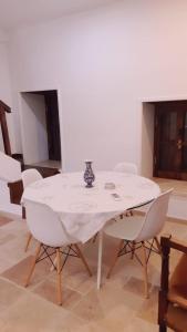 a white table with chairs and a vase on it at Malia Fountain House in Famagusta