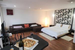 a living room with a bed and a pizza on a table at Apartament curat si confortabil in centru Str. Armeneasca 47 in Chişinău