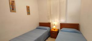 1 Schlafzimmer mit 2 Betten, einer Lampe und einem Fenster in der Unterkunft ACV - Costa Caribe II-2ª Linea Planta 4 Sur in Oropesa del Mar + 19 Fotos