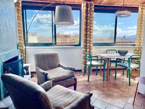 a living room with a table and chairs and windows at Loft Aragonese in Palermo