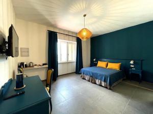 a bedroom with a bed and a blue wall at Isolotto Guest House in Porto Ercole
