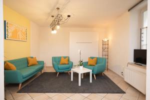 een woonkamer met twee blauwe stoelen en een tafel bij Suite - Sweet MayLeen in Merano